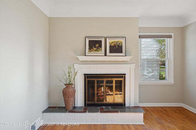 room details with a brick fireplace, baseboards, and wood finished floors