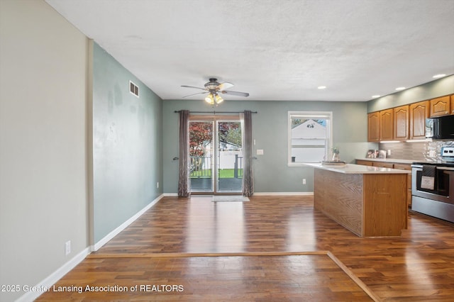 kitchen featuring stainless steel electric range oven, black microwave, a ceiling fan, wood finished floors, and visible vents