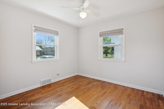 spare room with baseboards, plenty of natural light, and visible vents