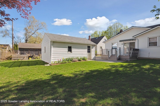 back of house featuring a yard and a deck