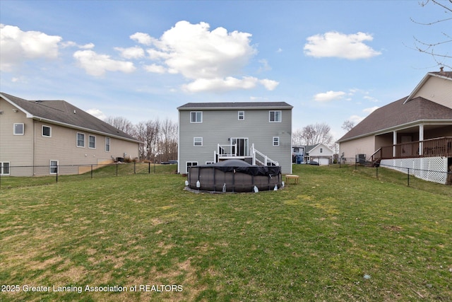 back of house featuring a fenced in pool, a fenced backyard, and a yard