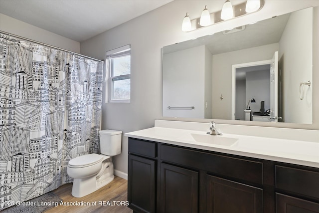 full bath featuring wood finished floors, curtained shower, vanity, baseboards, and toilet