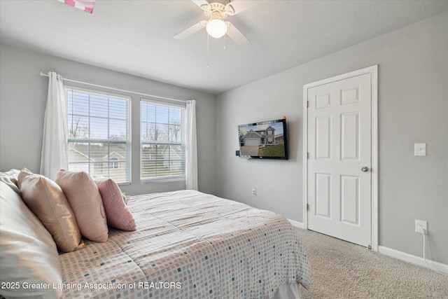 carpeted bedroom featuring baseboards and a ceiling fan