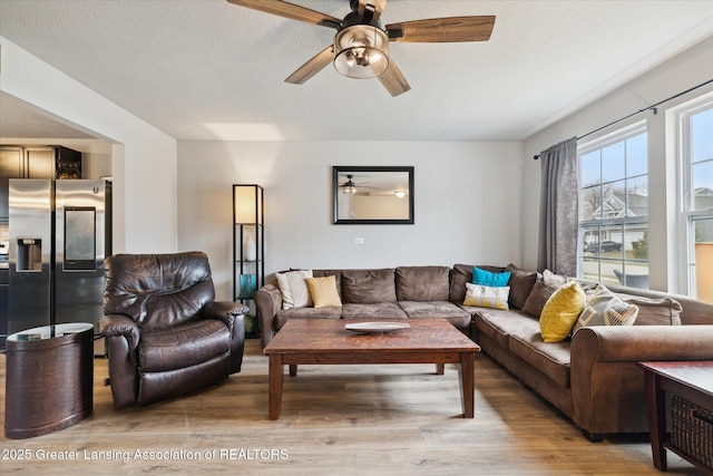 living area with ceiling fan and light wood-style flooring