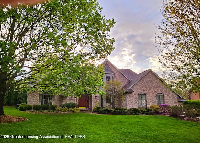 view of front of property featuring brick siding and a front yard