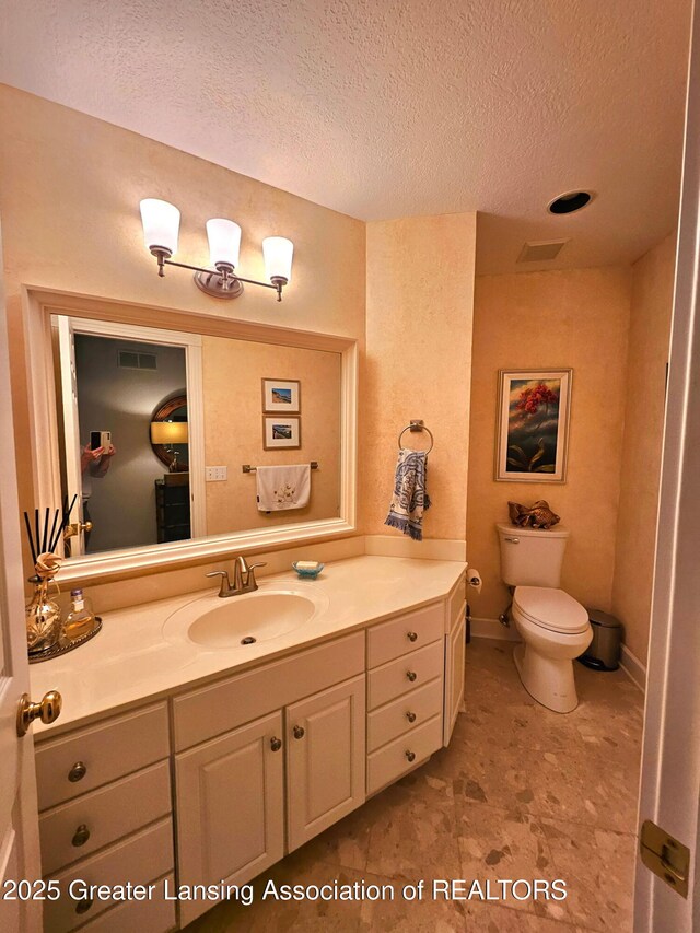 bathroom featuring vanity, toilet, a textured ceiling, and visible vents