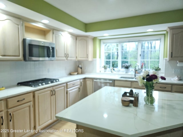 kitchen featuring recessed lighting, a center island, a sink, backsplash, and stainless steel appliances