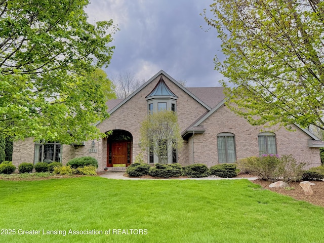 view of front facade with brick siding and a front lawn