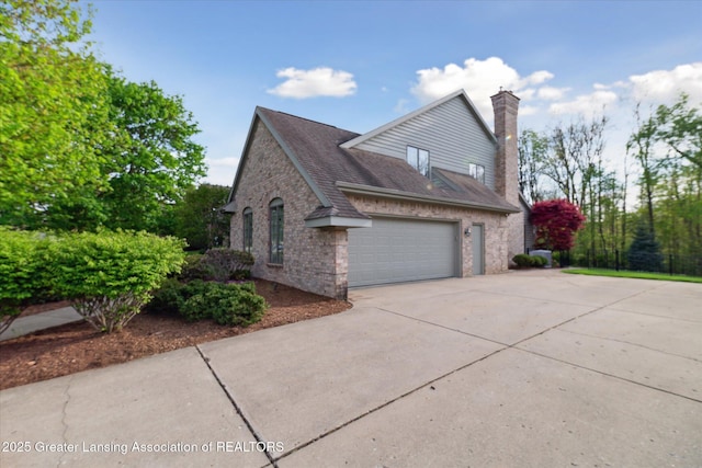 3641 Beech Tree Ln, Okemos, MI 48864 - view of property exterior with an attached garage, driveway, a chimney, brick siding, and roof with shingles