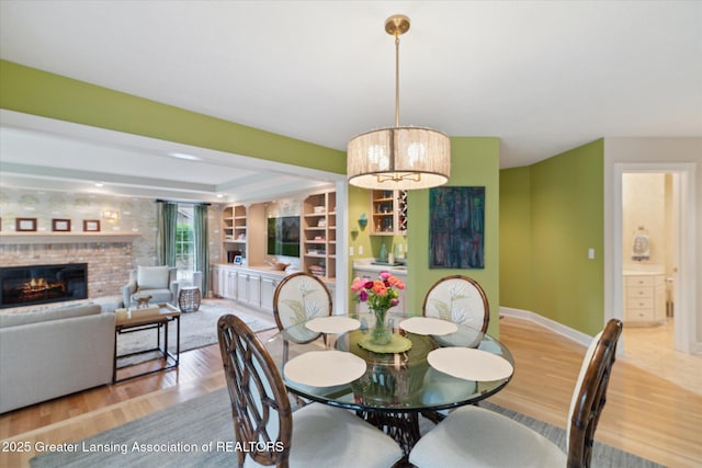 3641 Beech Tree Ln, Okemos, MI 48864 - dining space with light wood-style flooring, a fireplace, and baseboards