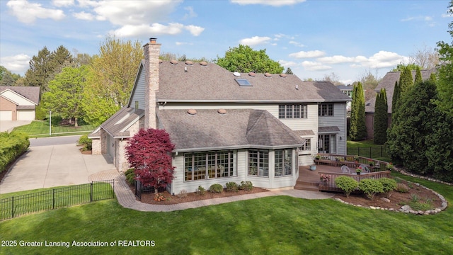 3641 Beech Tree Ln, Okemos, MI 48864 - rear view of house with driveway, a wooden deck, a garage, and a chimney