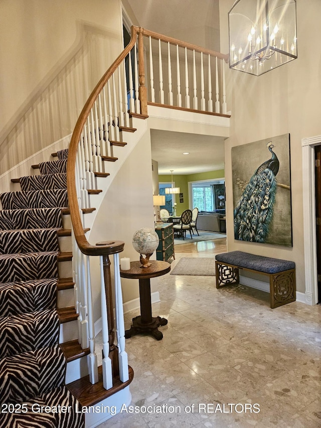 3641 Beech Tree Ln, Okemos, MI 48864 - staircase featuring a chandelier, a high ceiling, baseboards, and marble finish floors
