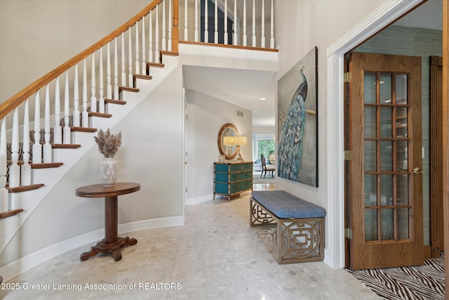 3641 Beech Tree Ln, Okemos, MI 48864 - staircase featuring a towering ceiling and baseboards