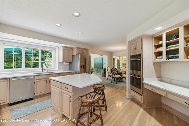 3641 Beech Tree Ln, Okemos, MI 48864 - kitchen featuring stainless steel appliances, light brown cabinets, a kitchen bar, and recessed lighting