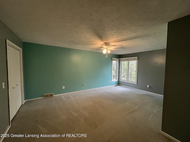 1425 E Lakeside Dr, East Lansing, MI 48823 - unfurnished room featuring ceiling fan, a textured ceiling, visible vents, baseboards, and carpet