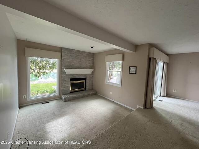 1425 E Lakeside Dr, East Lansing, MI 48823 - unfurnished living room with baseboards, visible vents, carpet, and a fireplace