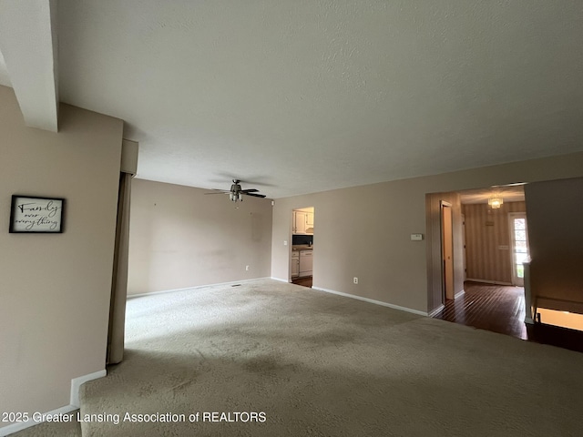 1425 E Lakeside Dr, East Lansing, MI 48823 - unfurnished living room featuring carpet floors, ceiling fan, and baseboards