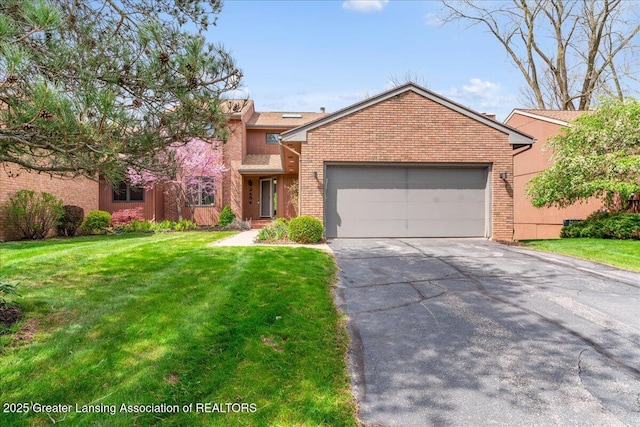 2454 Emerald Lake Dr, East Lansing, MI 48823 - view of front facade with brick siding, a front lawn, an attached garage, and driveway