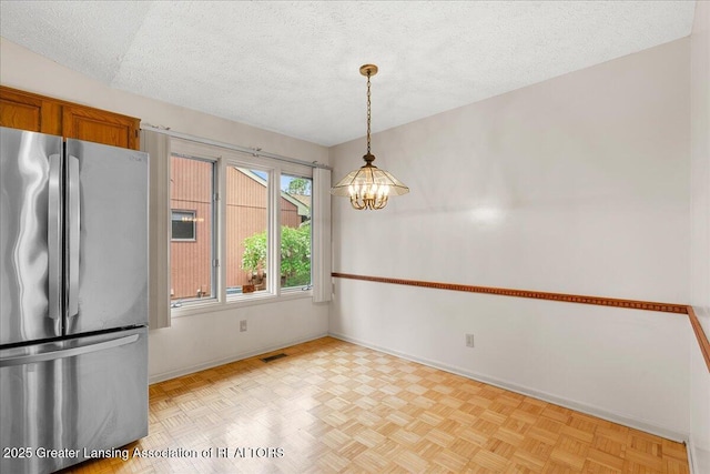2454 Emerald Lake Dr, East Lansing, MI 48823 - unfurnished dining area featuring baseboards, visible vents, a textured ceiling, and a chandelier