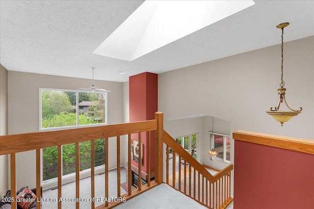2454 Emerald Lake Dr, East Lansing, MI 48823 - hallway featuring carpet floors, a textured ceiling, a skylight, and an upstairs landing