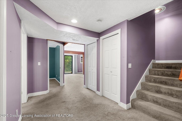 2454 Emerald Lake Dr, East Lansing, MI 48823 - staircase featuring carpet floors, baseboards, and a textured ceiling