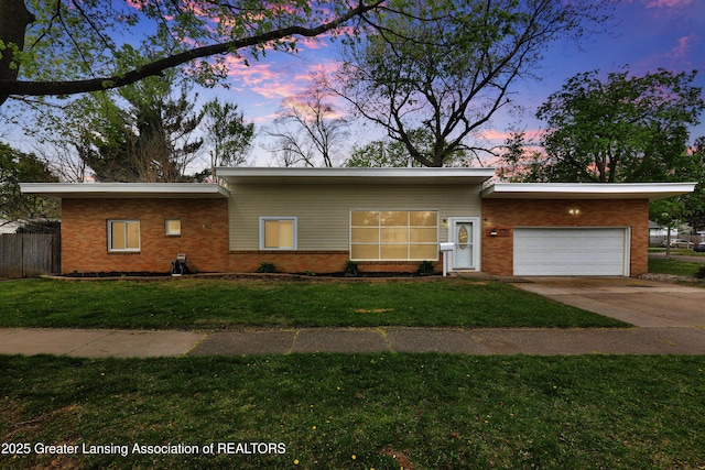 ranch-style house with brick siding, driveway, a front yard, and a garage