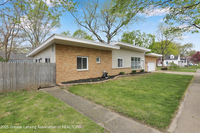 view of front facade with fence, an attached garage, a front lawn, brick siding, and concrete driveway