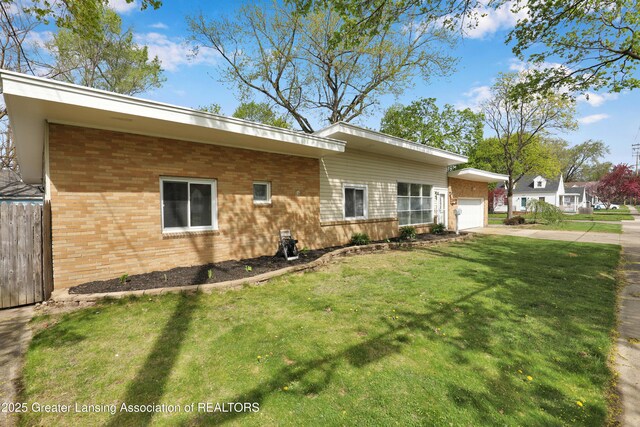 ranch-style house with a garage, fence, a front yard, brick siding, and driveway