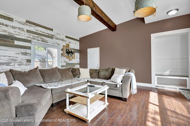 living area with baseboards, lofted ceiling with beams, an accent wall, and wood finished floors