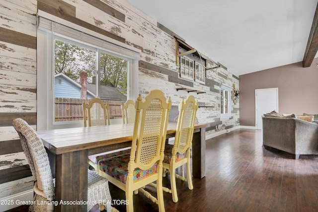 dining room featuring wood-type flooring, baseboards, and an accent wall