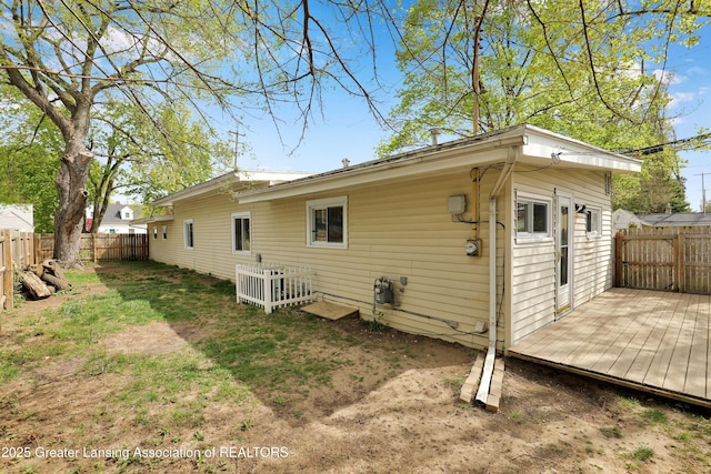 rear view of house with a deck and a fenced backyard