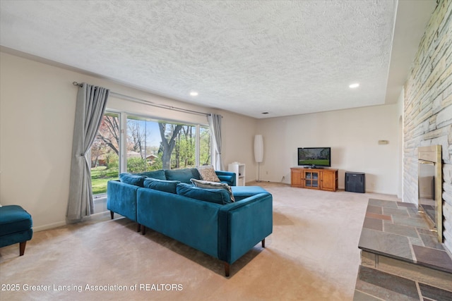 living room featuring recessed lighting, a textured ceiling, carpet, and a stone fireplace