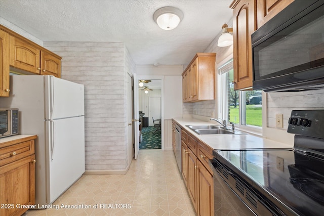 kitchen featuring ceiling fan, a textured ceiling, a sink, light countertops, and black appliances