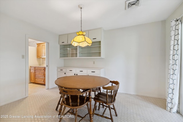 dining space with baseboards, light carpet, and visible vents