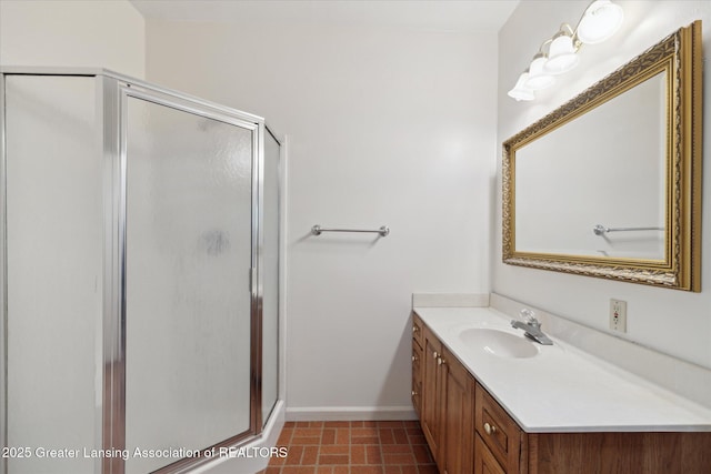 bathroom with baseboards, vanity, and a stall shower