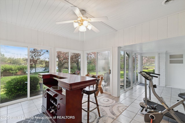 sunroom / solarium featuring a water view, tile patterned floors, wooden ceiling, and a healthy amount of sunlight