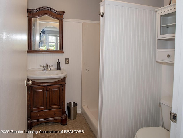 bathroom with vanity, walk in shower, tile patterned flooring, and toilet
