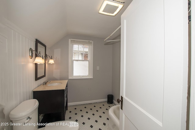 bathroom with vanity, lofted ceiling, toilet, baseboards, and tile patterned floors