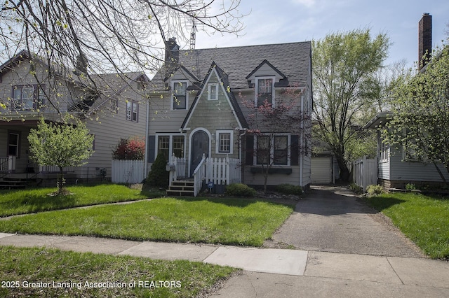 tudor house with a shingled roof and a front lawn