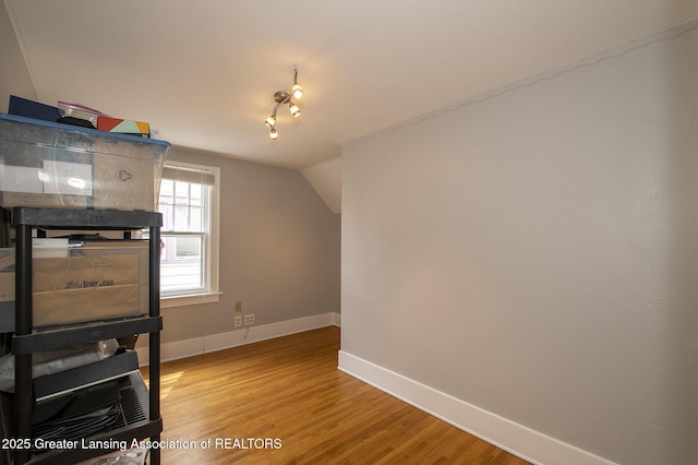bonus room featuring baseboards, light wood finished floors, and lofted ceiling