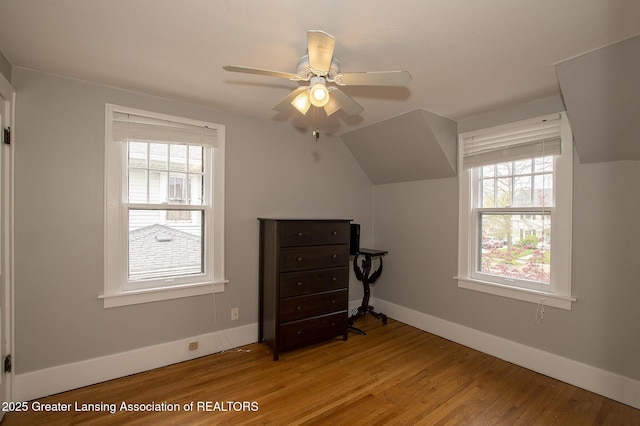 additional living space with a ceiling fan, baseboards, and wood finished floors