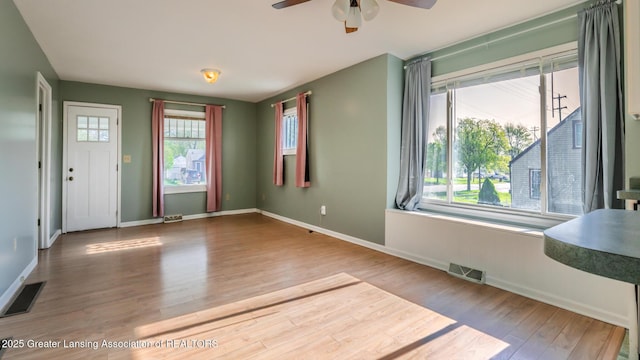 interior space featuring visible vents, baseboards, ceiling fan, and wood finished floors