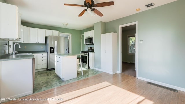 kitchen with stainless steel appliances, ceiling fan, visible vents, and a sink