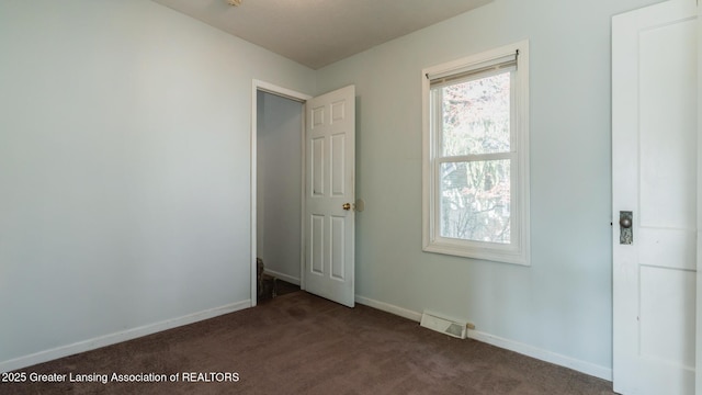 spare room featuring baseboards, visible vents, carpet flooring, and a wealth of natural light