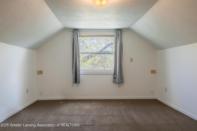 additional living space with carpet floors, baseboards, and vaulted ceiling
