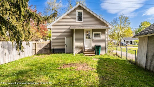 rear view of property with a lawn, fence private yard, and entry steps