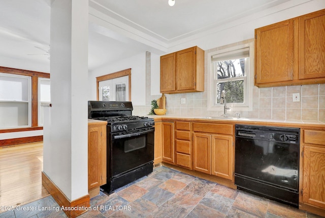 223 N Fairview, Lansing, MI 48912 - kitchen with tile countertops, a sink, black appliances, and tasteful backsplash