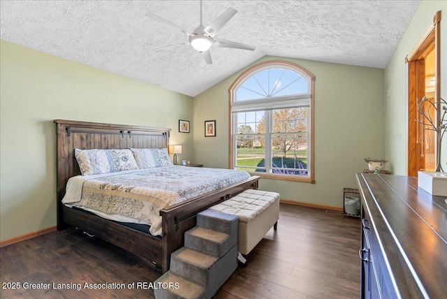 bedroom featuring dark wood-style flooring, lofted ceiling, baseboards, a textured ceiling, and a ceiling fan