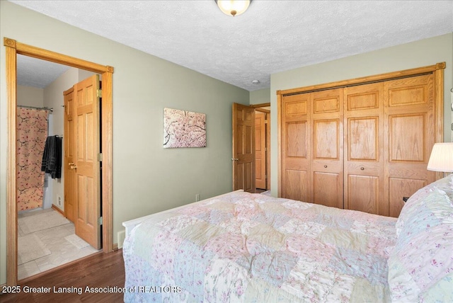 bedroom featuring a textured ceiling, wood finished floors, and a closet