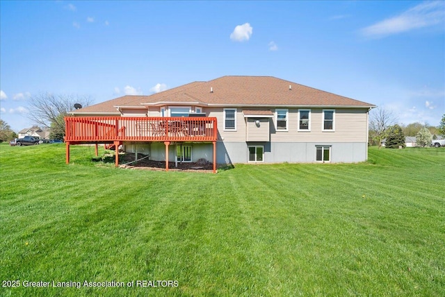 rear view of property with a yard and a wooden deck